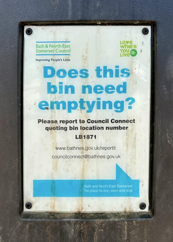 Sign on a bin saying ‘Does this bin need emptying?’ with a URL and a reference code for the specific bin